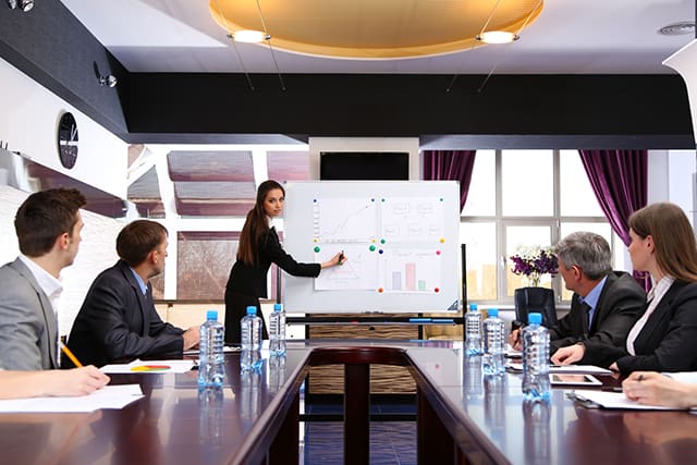 Professional trainer conducting ISO training session with employees in a Qatari business setting.