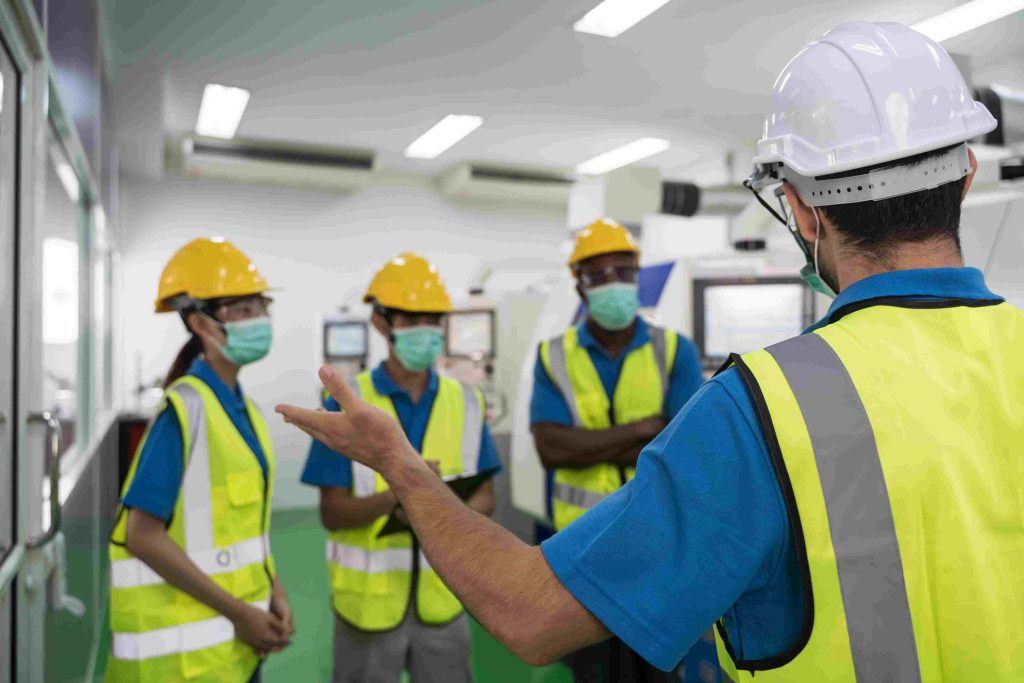 Safety officer conducting health and safety training for workers on-site in Qatar.