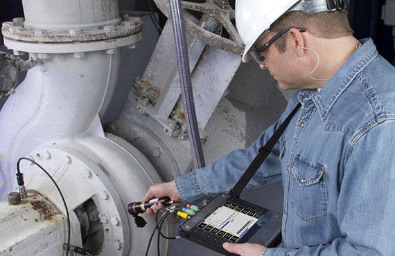 Technician conducting vibration exposure monitoring on industrial equipment in Qatar.