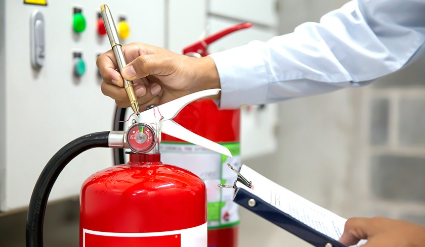 Fire Safety Inspection Qatar fire inspector examining equipment