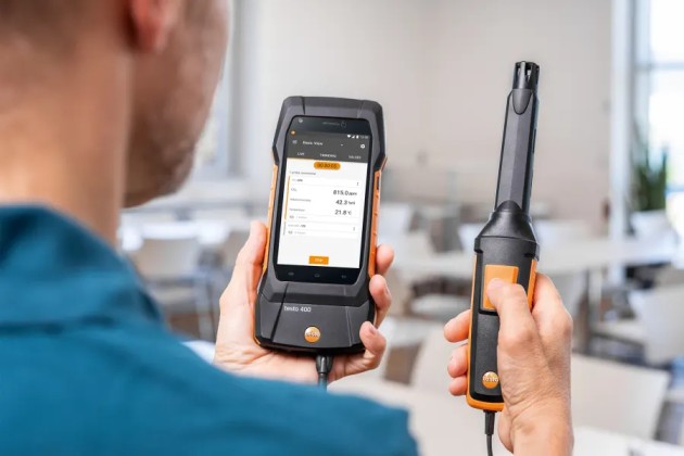 Specialist conducting a thermal comfort assessment in an indoor workplace in Qatar